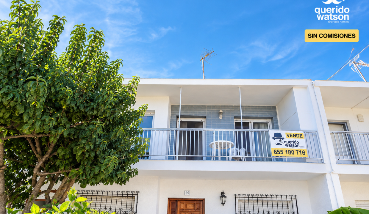 Adosado blanco con jardín y cartel de venta